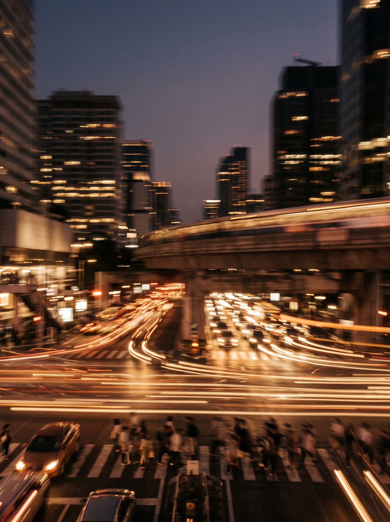 Warm streaks of city light at dusk — long-exposure motion blur evoking the pace of modern life